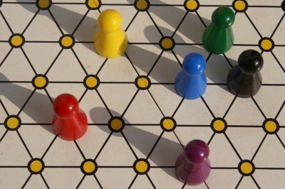 Sechs verschieden farbige Plastikspielfiguren auf einem Netz